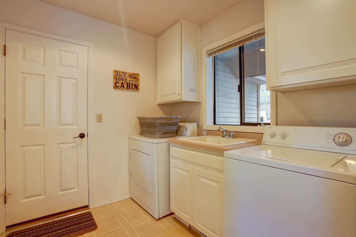 This large laundry room off the dining room features a utility sink and leads to the garage. 