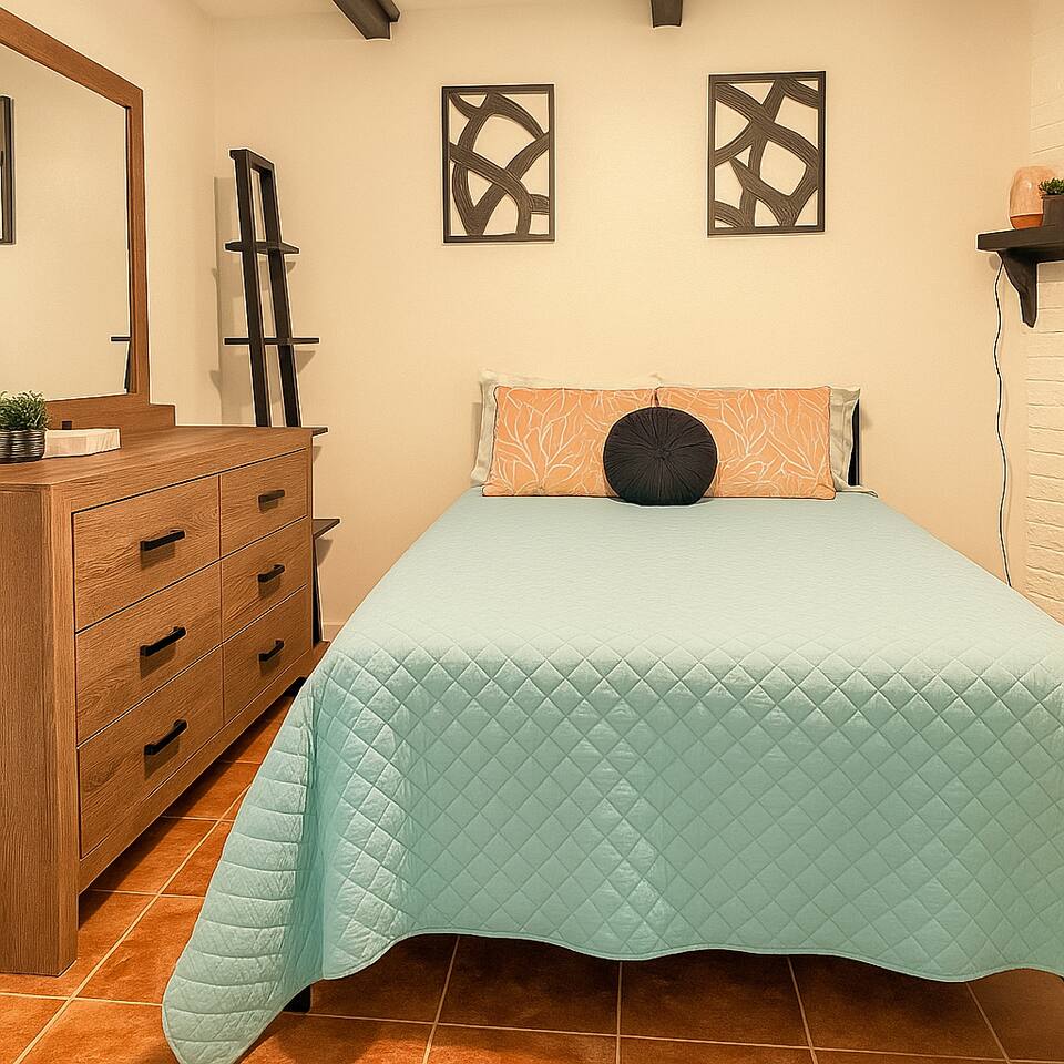 Simple and serene Full Sized bedroom with a dresser, ideal for solo travelers or kids who need their own space.