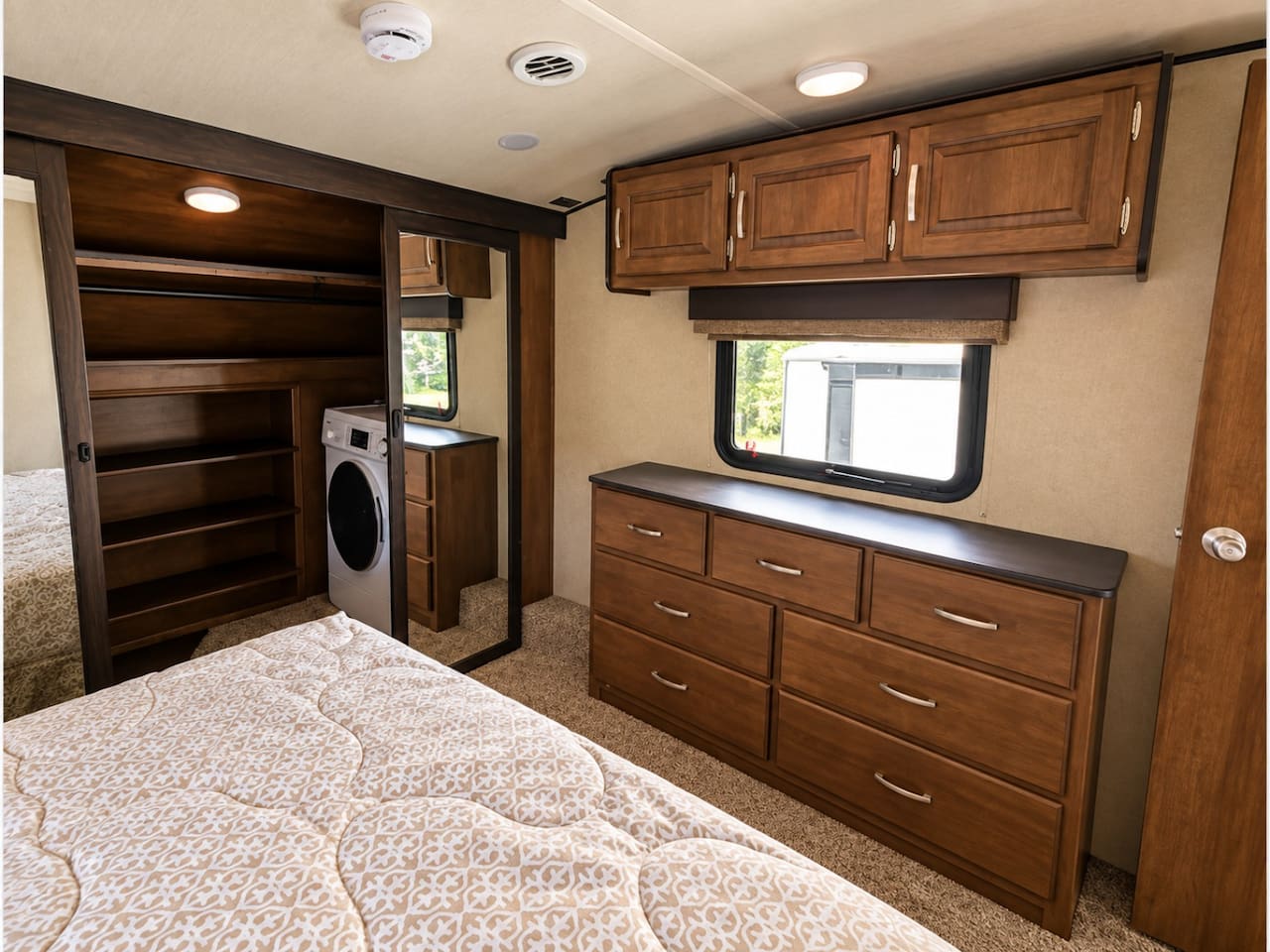 Bedroom with queen sized bed, bureau and closet with washing machine