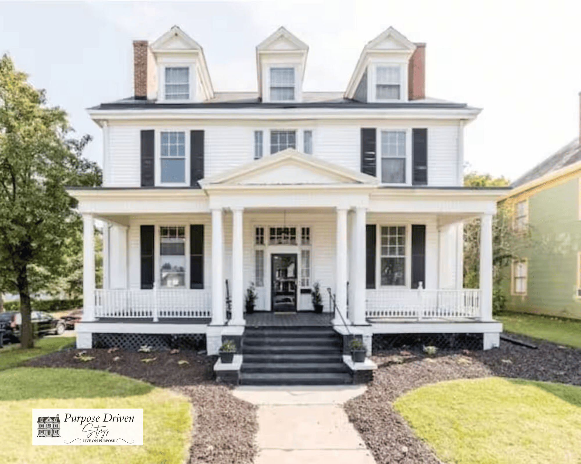 Stunning historic Victorian with beautiful front porch and rocking chairs.