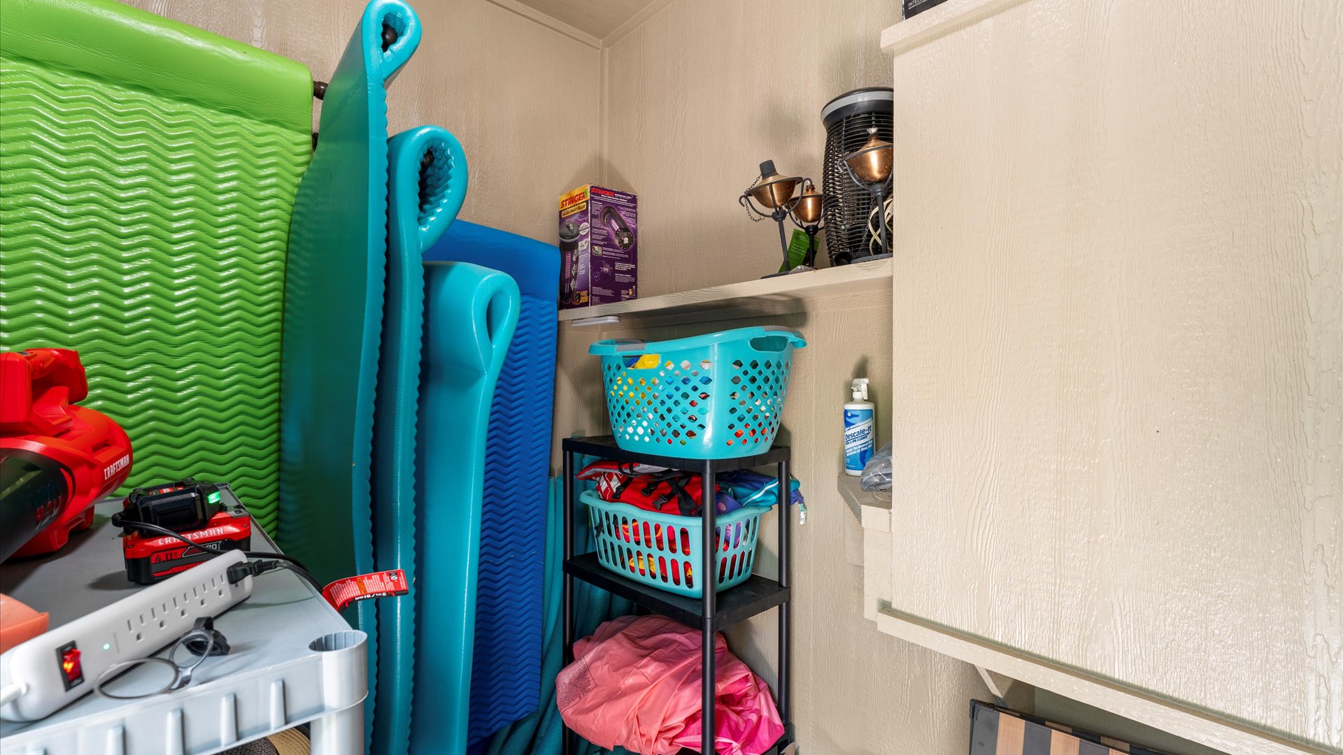 A well-stocked pool storage area filled with float mats, life vests, and outdoor essentials—everything you need for a fun and relaxing day by the pool!
