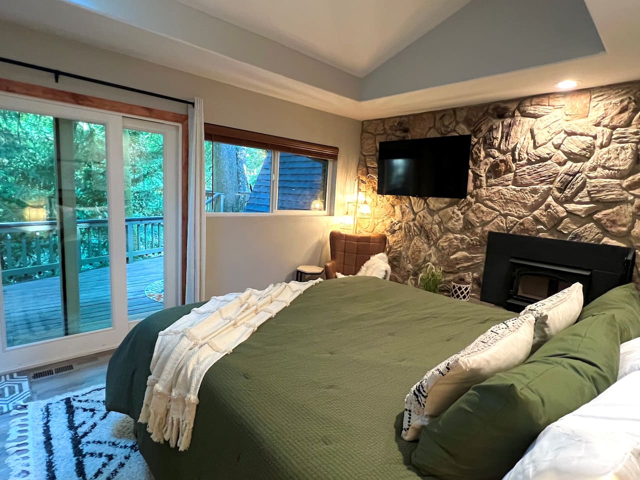 King bedroom with Wood Burning Fireplace, TV, Relaxation Station, and deck access