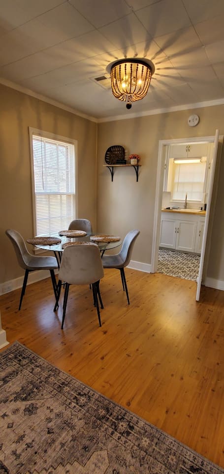 Stylish dining area with a modern round table, plush seating, and a statement light fixture—perfect for meals or gathering with friends.