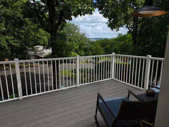Upper-level deck with peaceful lake views, outdoor seating and a relaxing spot to enjoy the wooded setting.