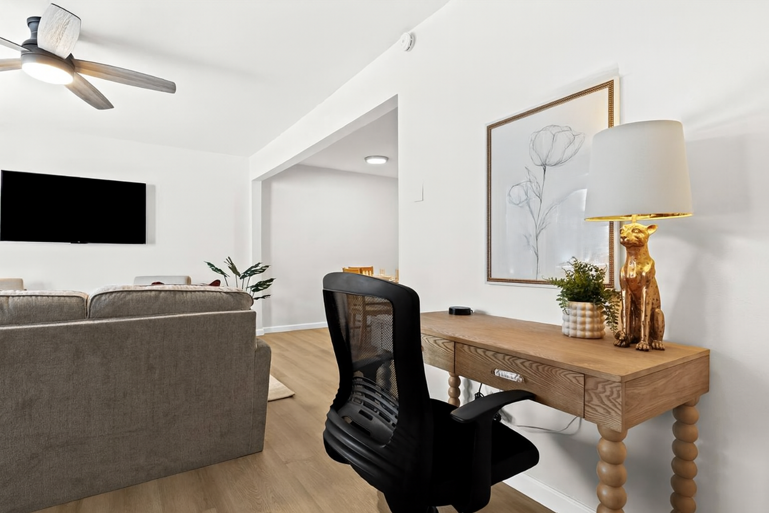 Chic and functional workspace with a rivet-trimmed desk, mesh chair, and cozy lamp—ideal for productivity.