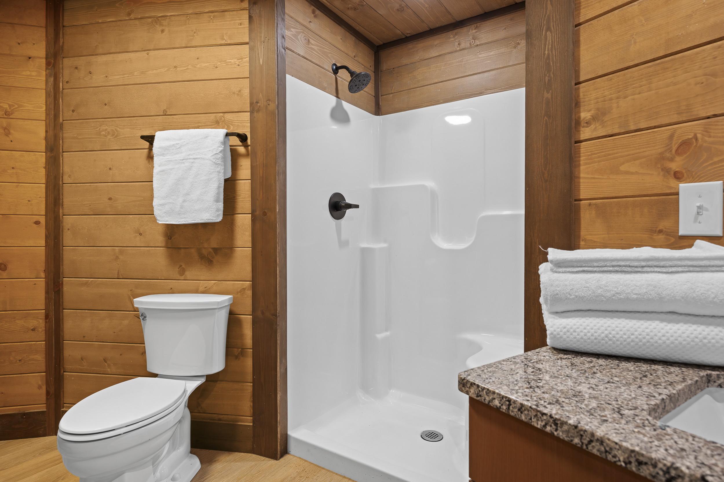 Spa-Like Retreat: Enjoy modern comforts in a wood-clad bathroom with stylish fixtures!