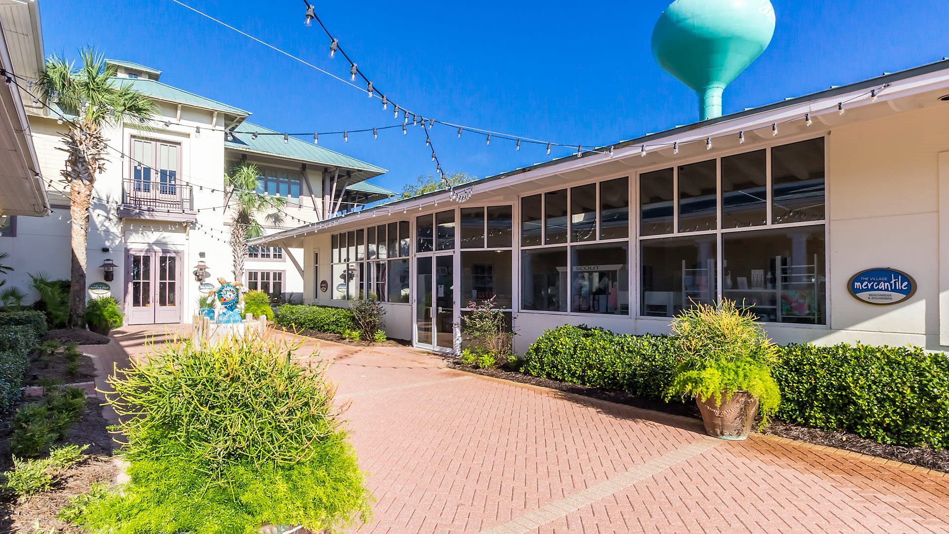 The vibrant heart of The Beach Club Resort entrance: The Village Square. Discover a delightful array of restaurants, amenities, and stores, all conveniently located to enhance your stay.