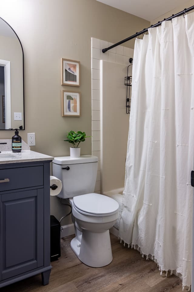 Curated art and a fresh green accent turn the everyday shower into a small daily luxury.