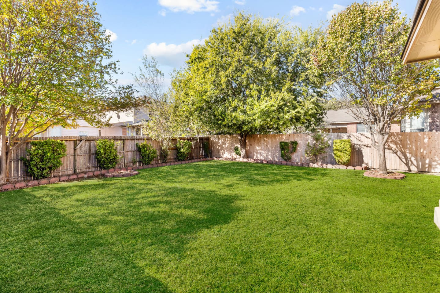 Private fenced yard featuring a gas BBQ grill with tools, perfect for outdoor meals, gatherings, and getaway vibes.
