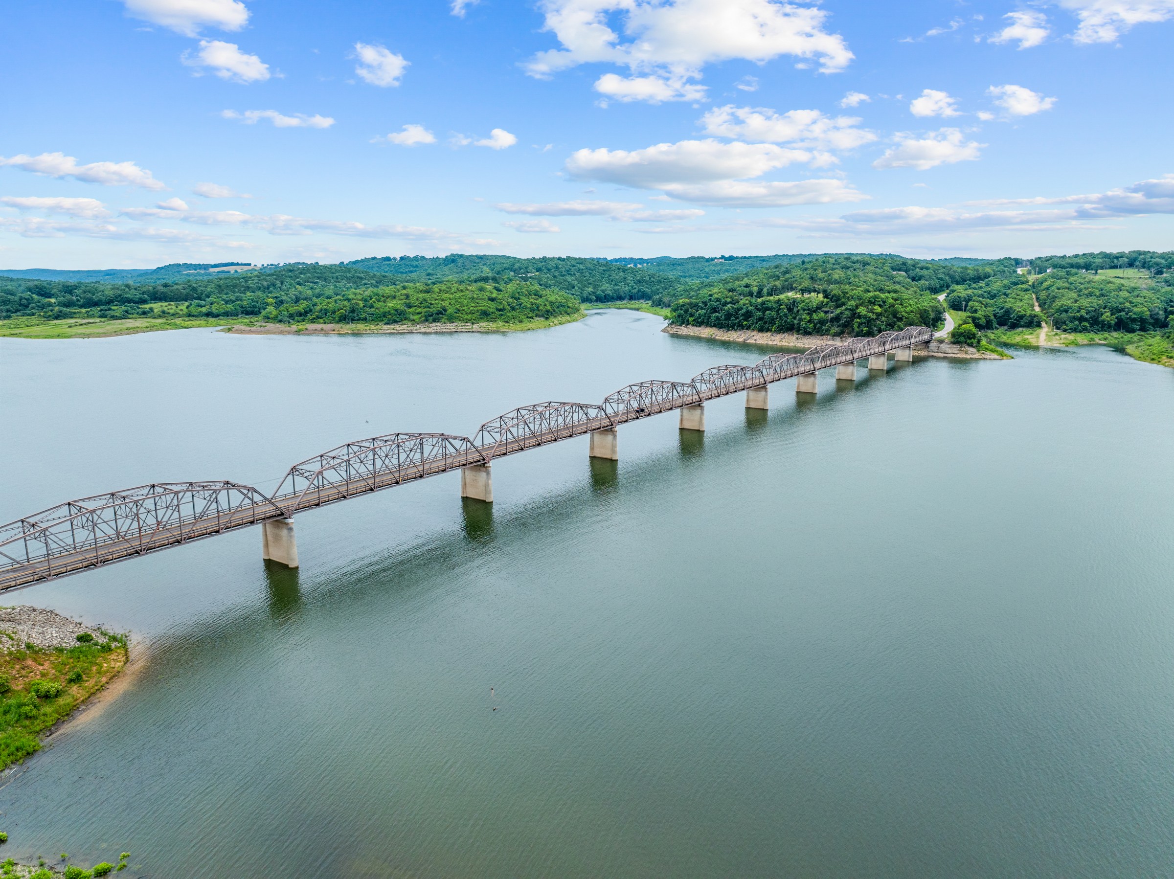 Nearby: aerial of the lake with a long steel truss bridge. Part of the Ozark lake scenery around the house.