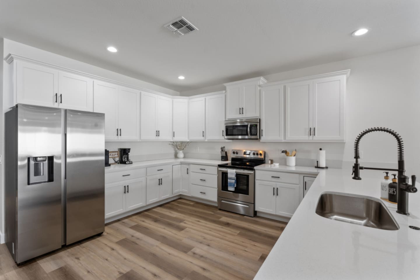Full kitchen with stainless steel appliances, white cabinetry, dishwasher, and plenty of counter space for everyday meals.