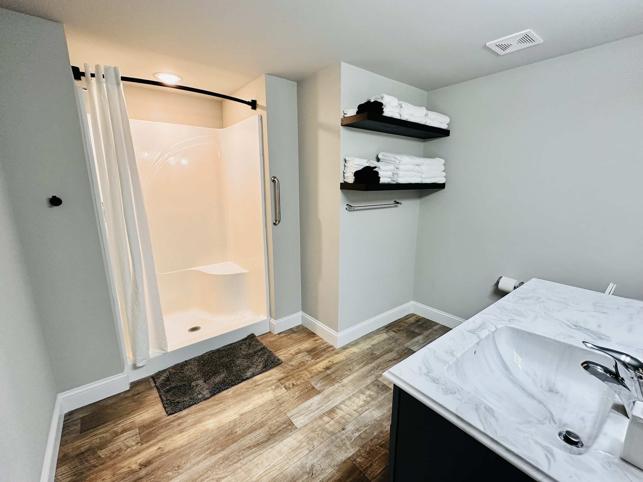 Large bathroom with full shower and plenty of towels.