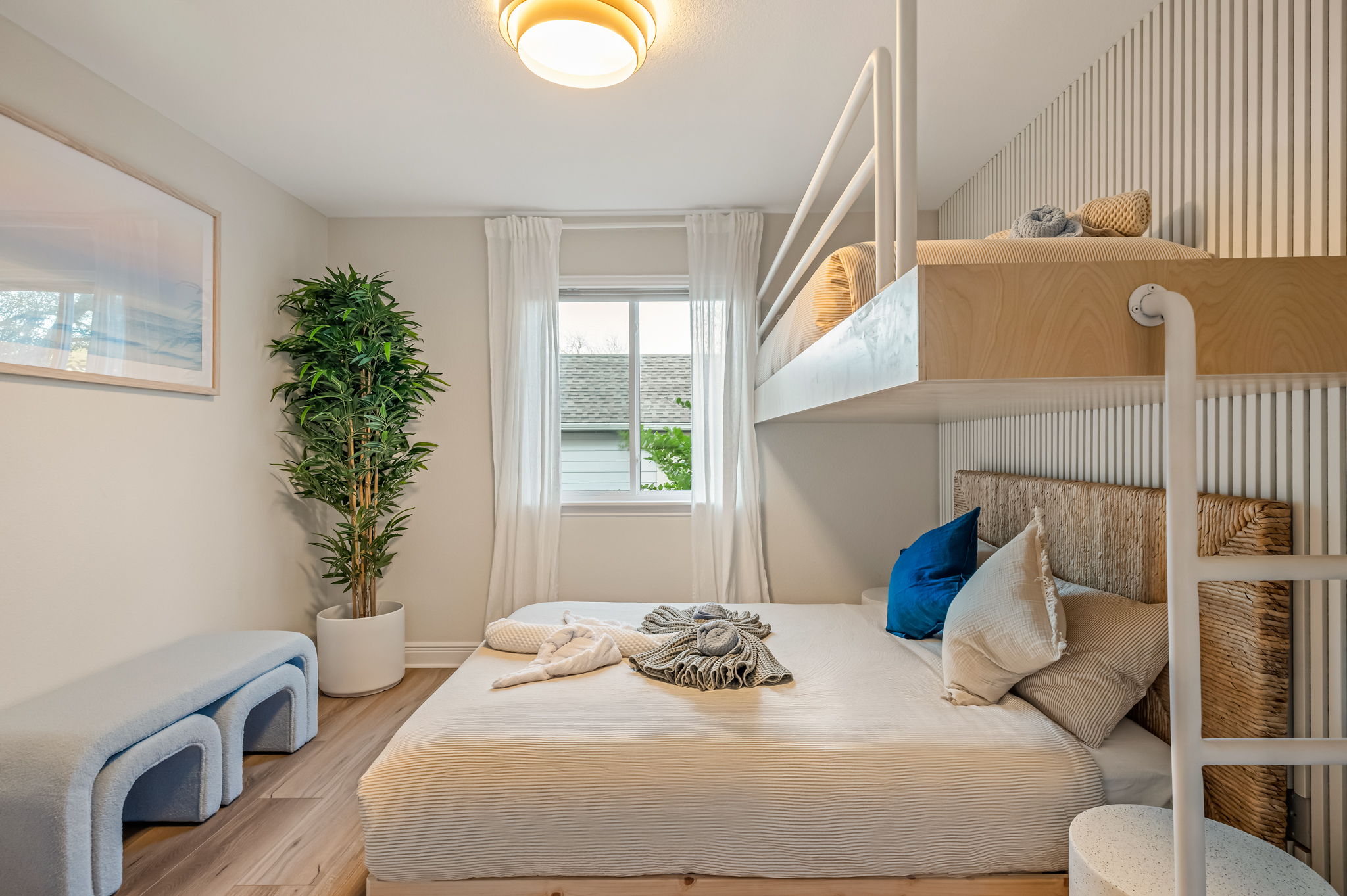 Spacious bunk bedroom with cozy queen bed below and twin bunks above — great for families.