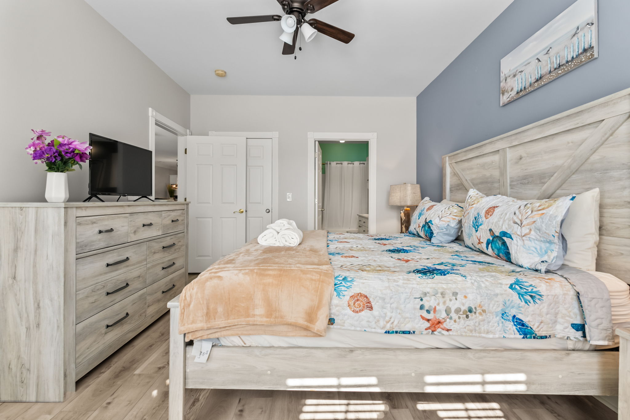 A spacious master bedroom with a flat-screen TV, cozy bedding, and stylish decor—creating the perfect blend of comfort and elegance for a restful retreat