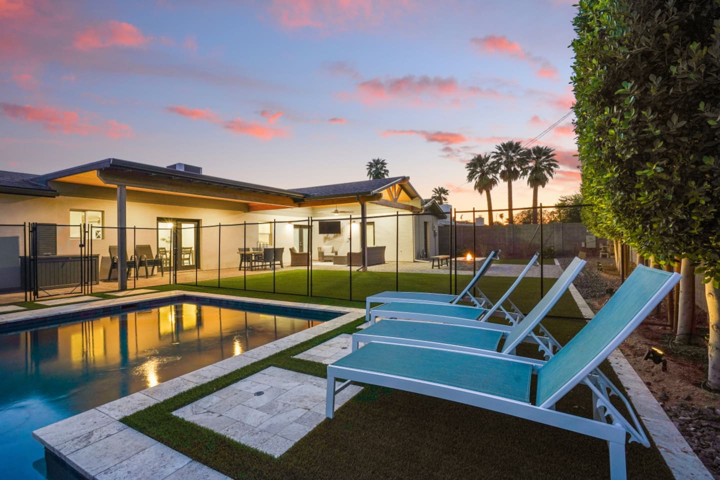 Private backyard pool with lounge chairs, umbrella shade, fire pit seating, and a bright outdoor space 