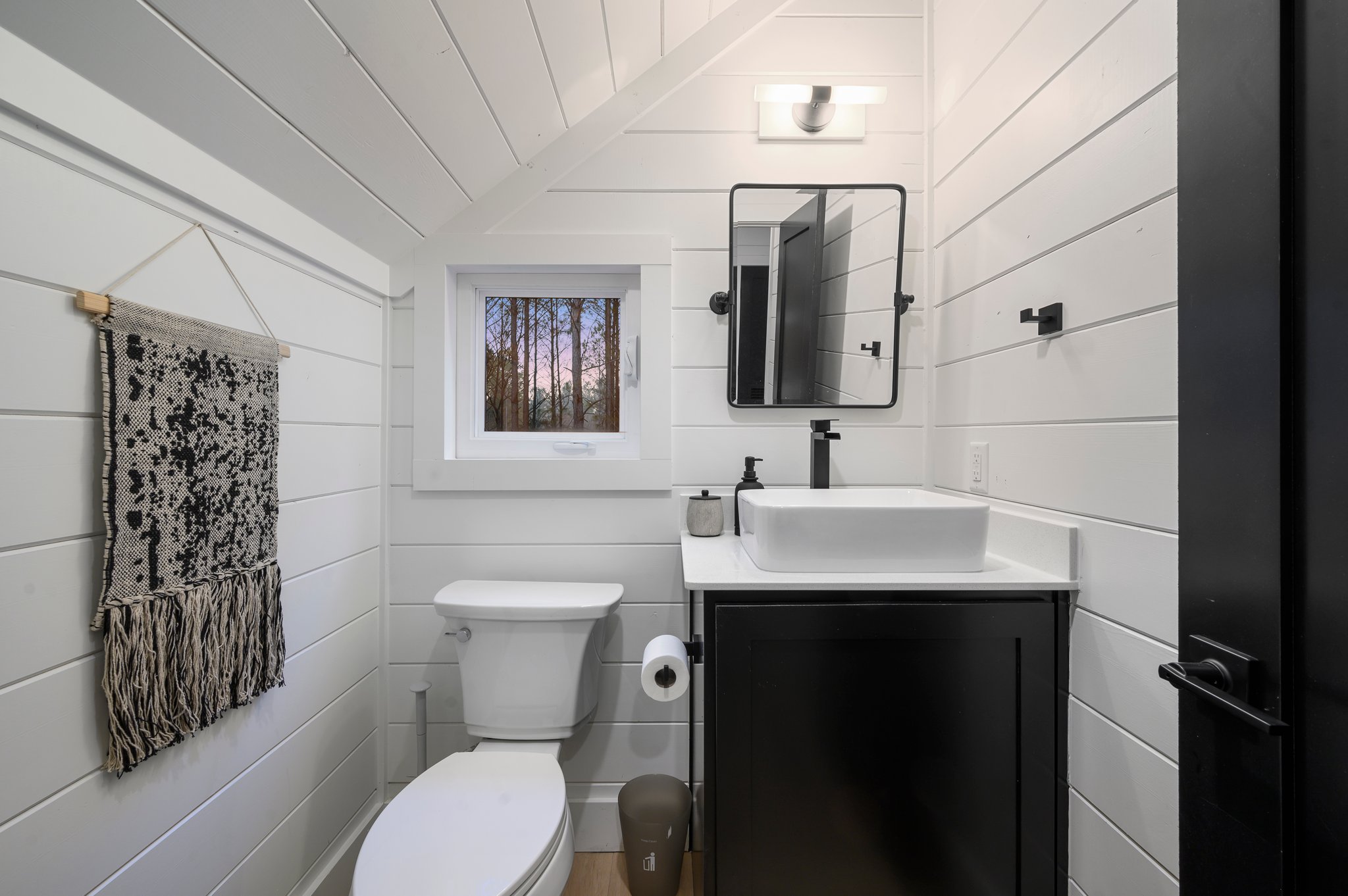 Compact yet beautifully appointed, this guest bathroom blends modern design with cozy cabin charm.