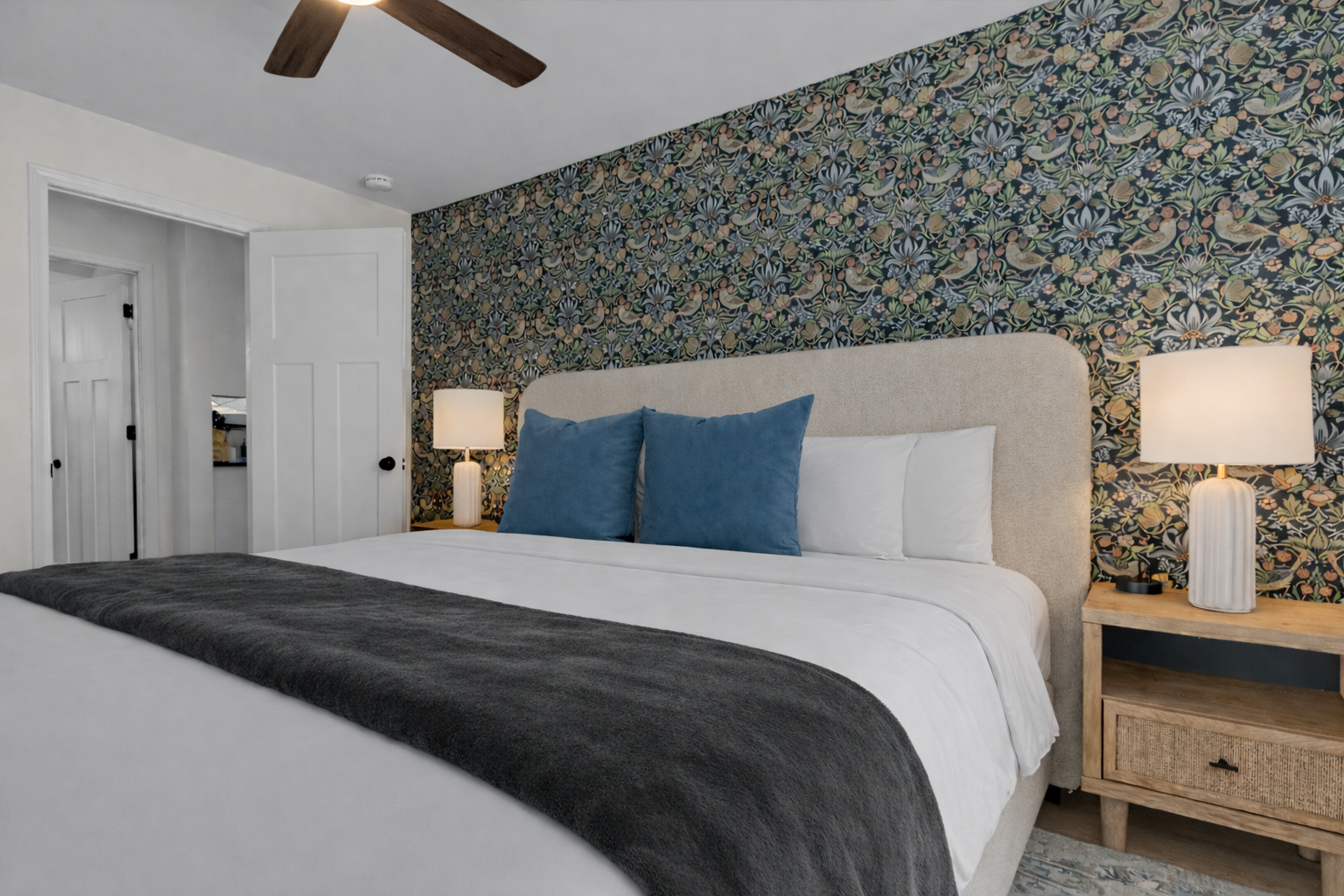 Comfortable, thoughtfully designed bedroom with a plush bed, ceiling fan, soft lighting, and a stylish accent wall for a relaxing retreat.