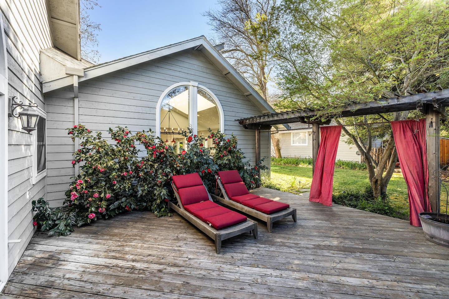 Secluded deck off the primary bedroom. Around the corner, across the lawn, there is the white outdoor chairs and pool table.