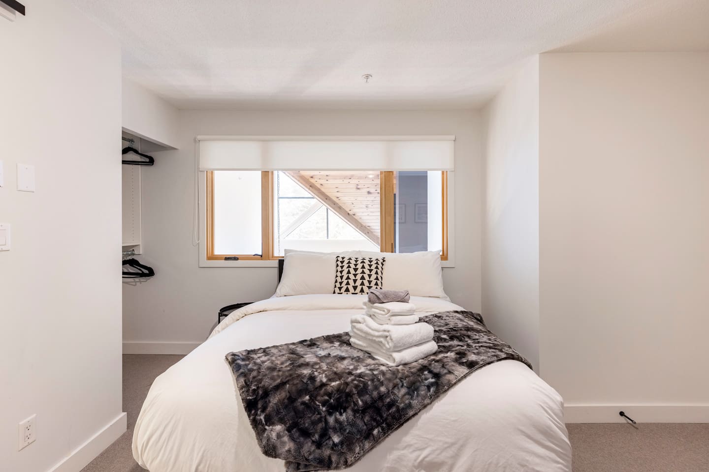 Upstairs bedroom looks out to the exterior windows and the downstairs living space.