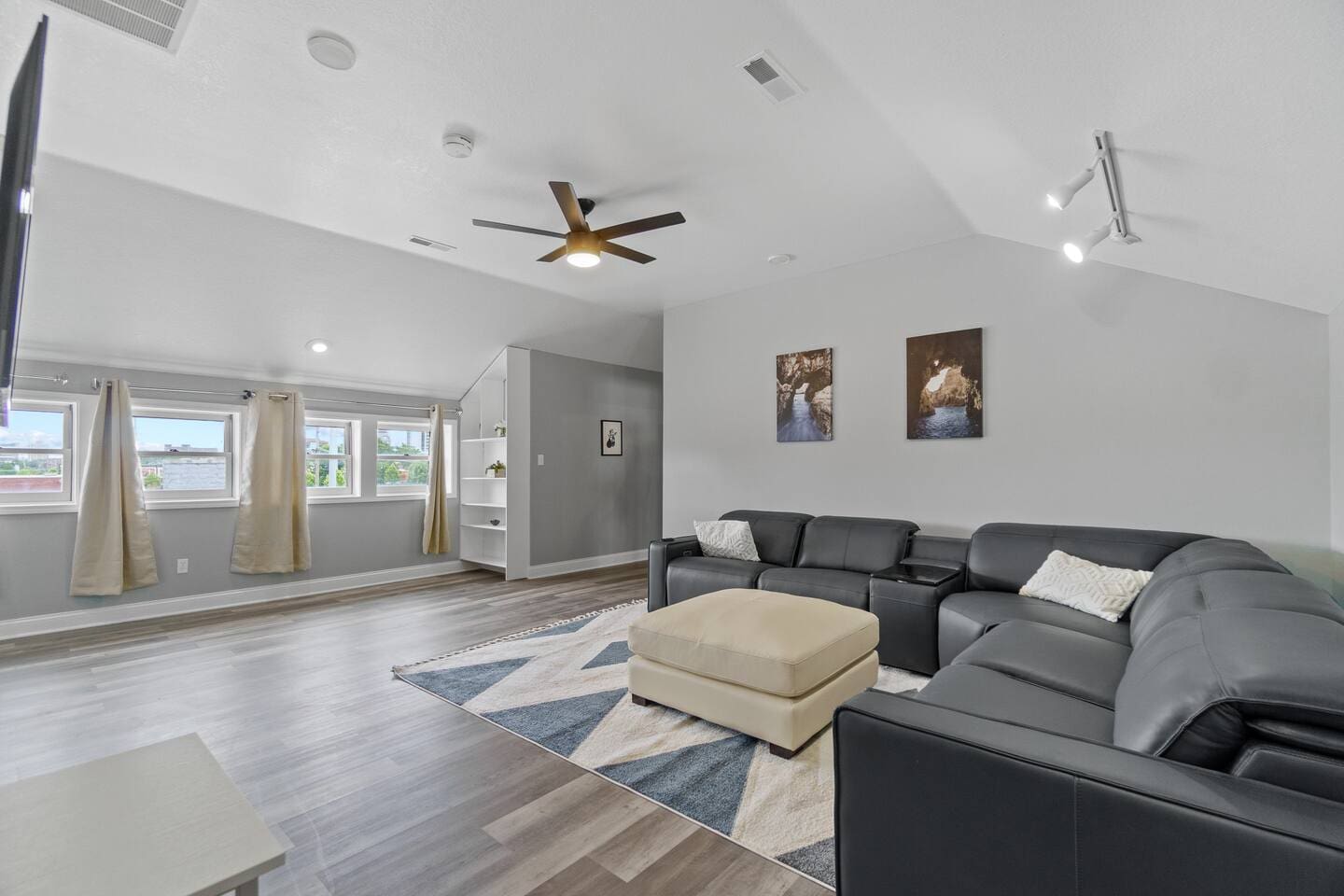 Spacious living room with comfortable couches and large windows, allowing plenty of natural light to fill the room and create a bright, airy atmosphere.