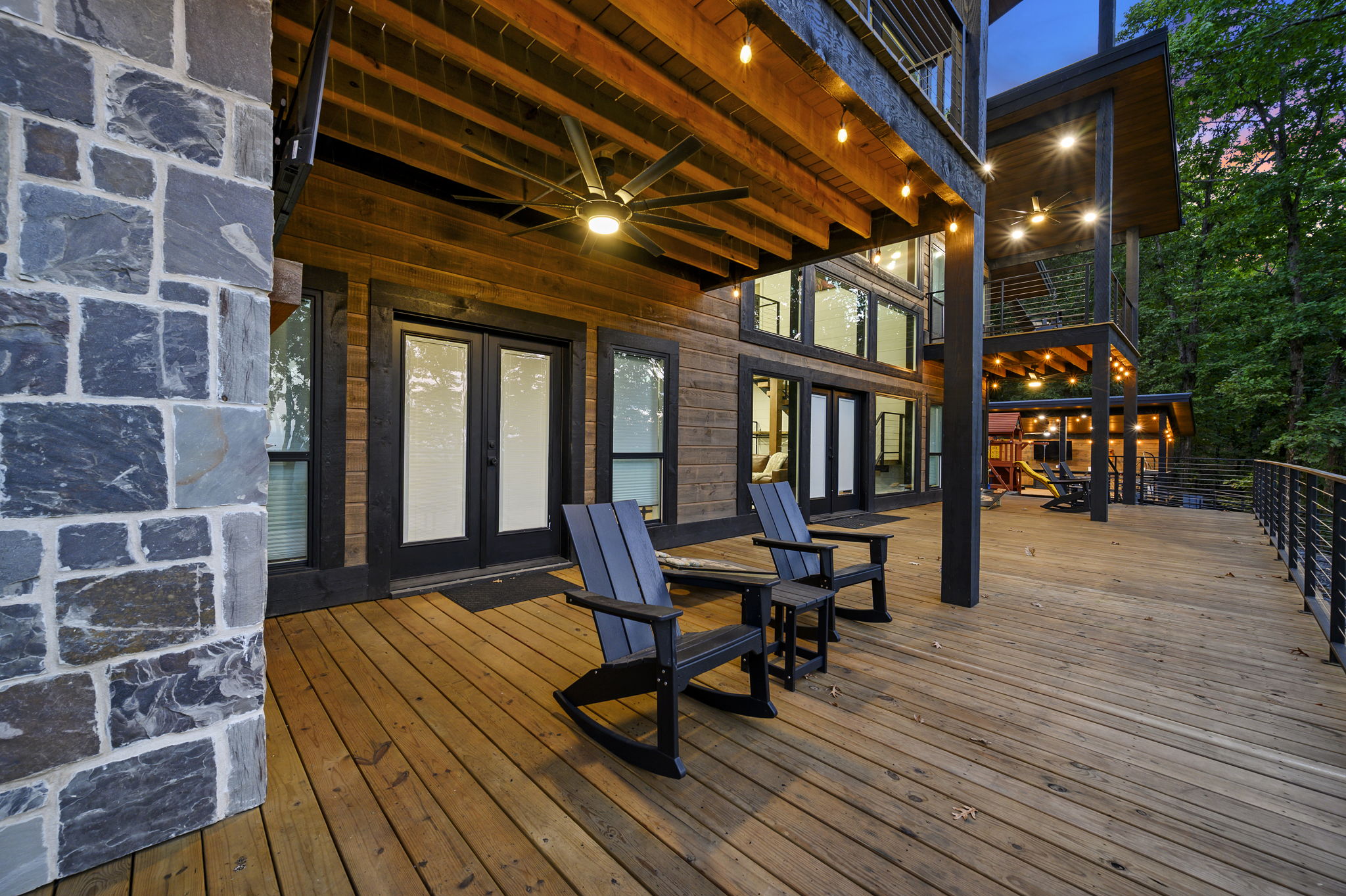 The huge main deck is made for relaxing and entertaining, with a fireplace, TV, cornhole, seating, and incredible mountain views.
