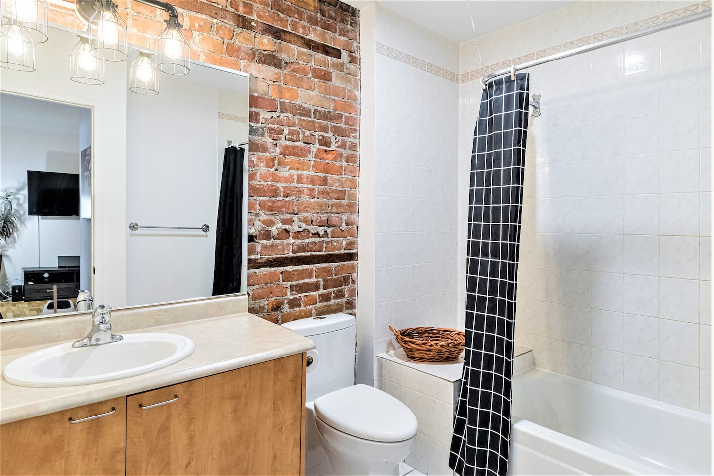 Salle de bain fonctionnel accueillant un mur de brique d'origine.