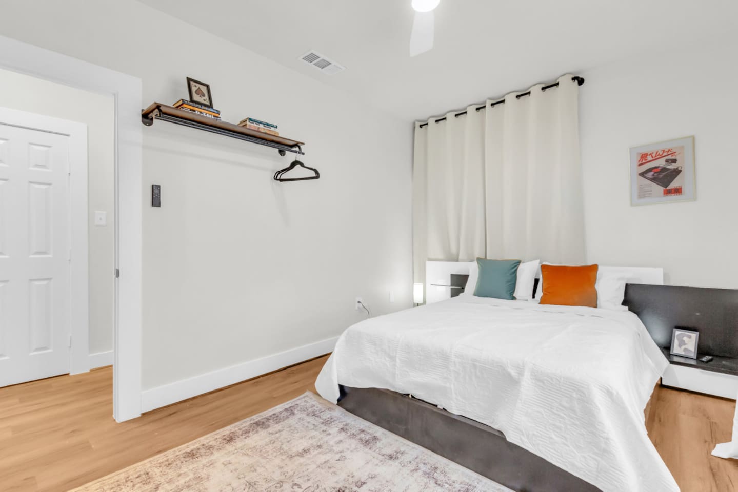 Main bedroom with queen bed, room darkening shades, hangars, and modern decor.