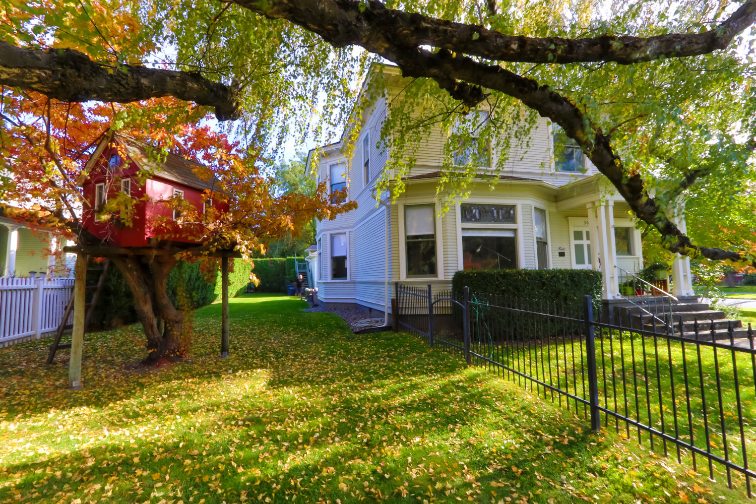 Front entrance and side of the home with red tree house perfect for the kids. 