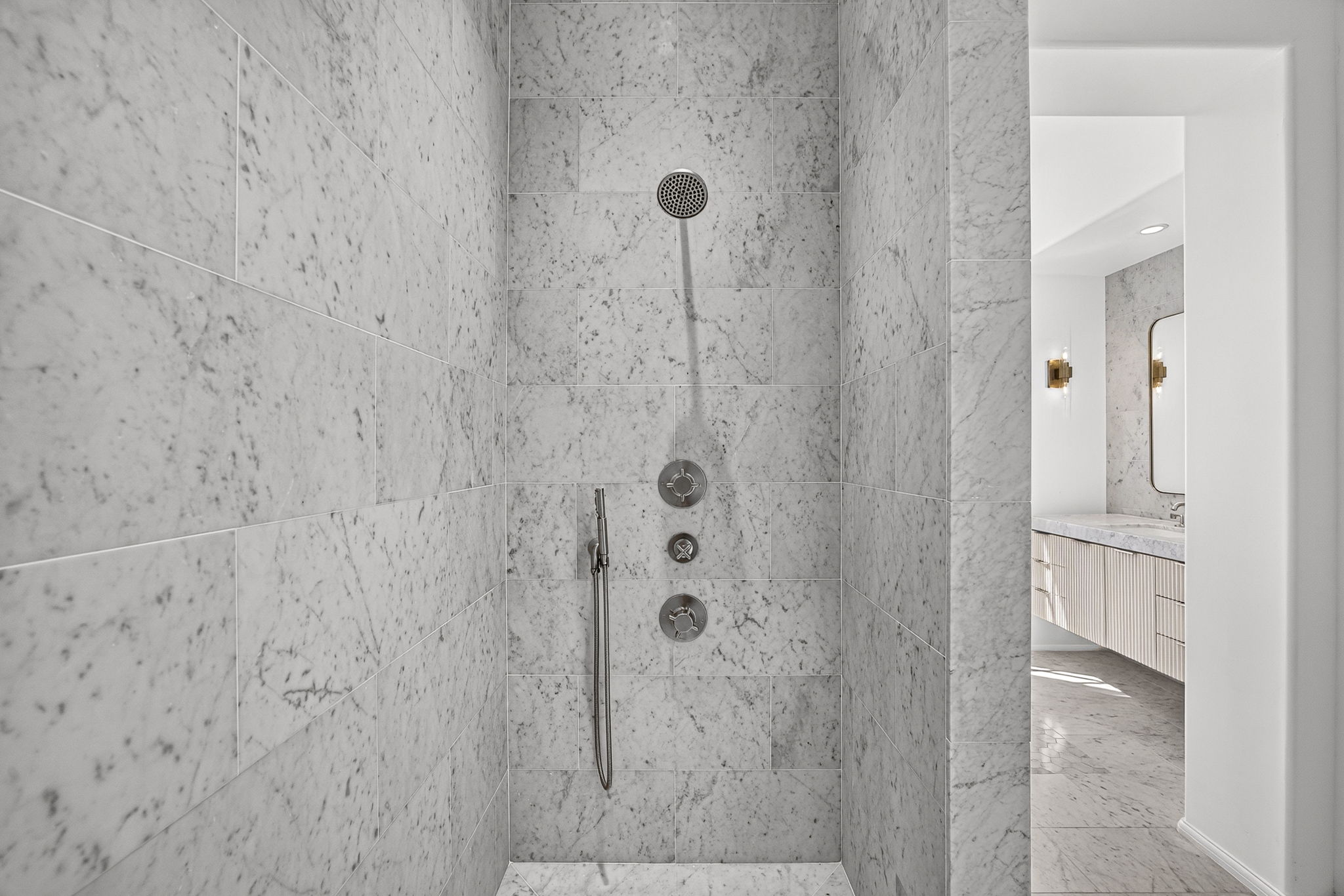 The luxurious marble shower is located in the primary bathroom.
