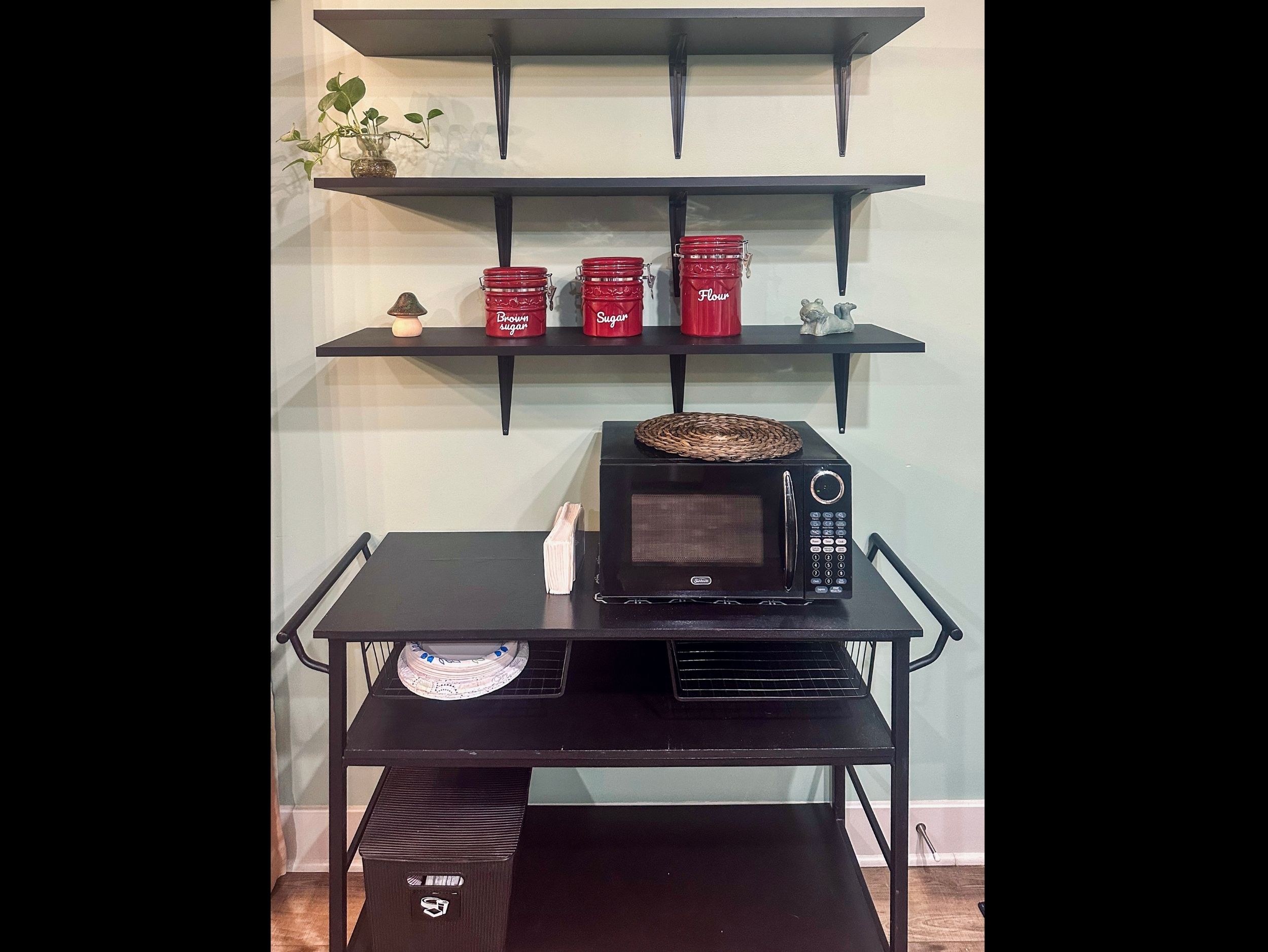 Utility cart featuring a microwave and additional storage, with open shelving displaying convenient pantry staples.