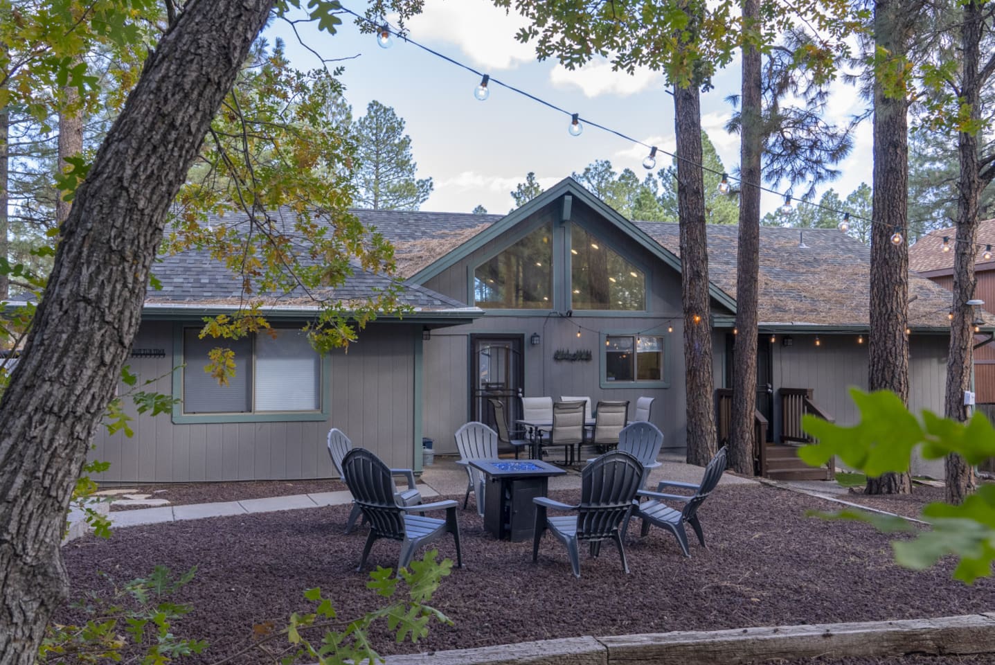 Outdoor space with pine trees, seating, and a peaceful setup for evenings outside.