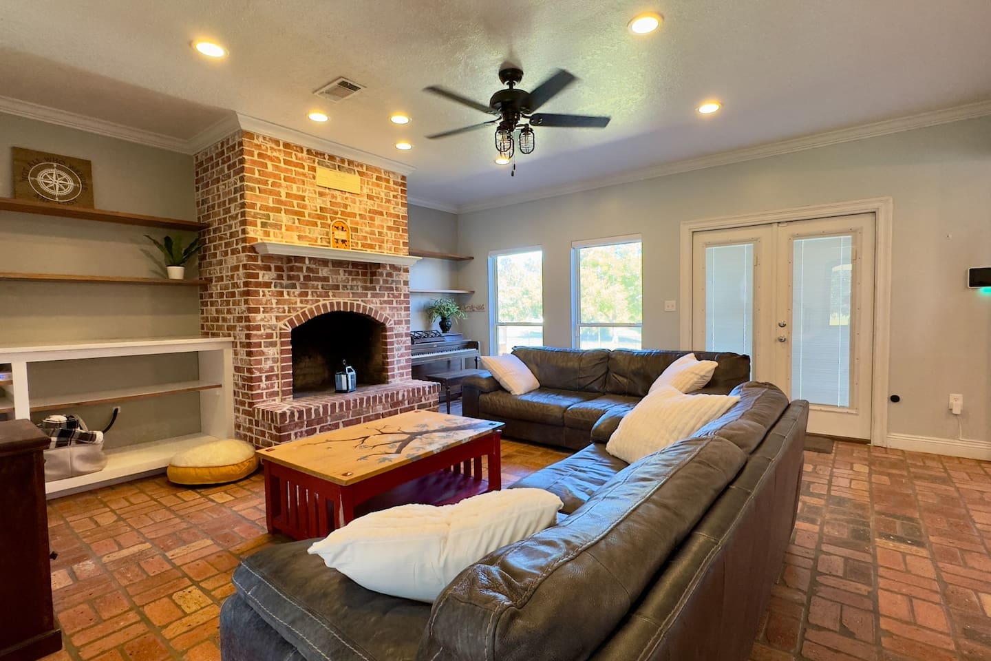 A spacious living room centered around a striking brick fireplace, perfect for evenings spent together