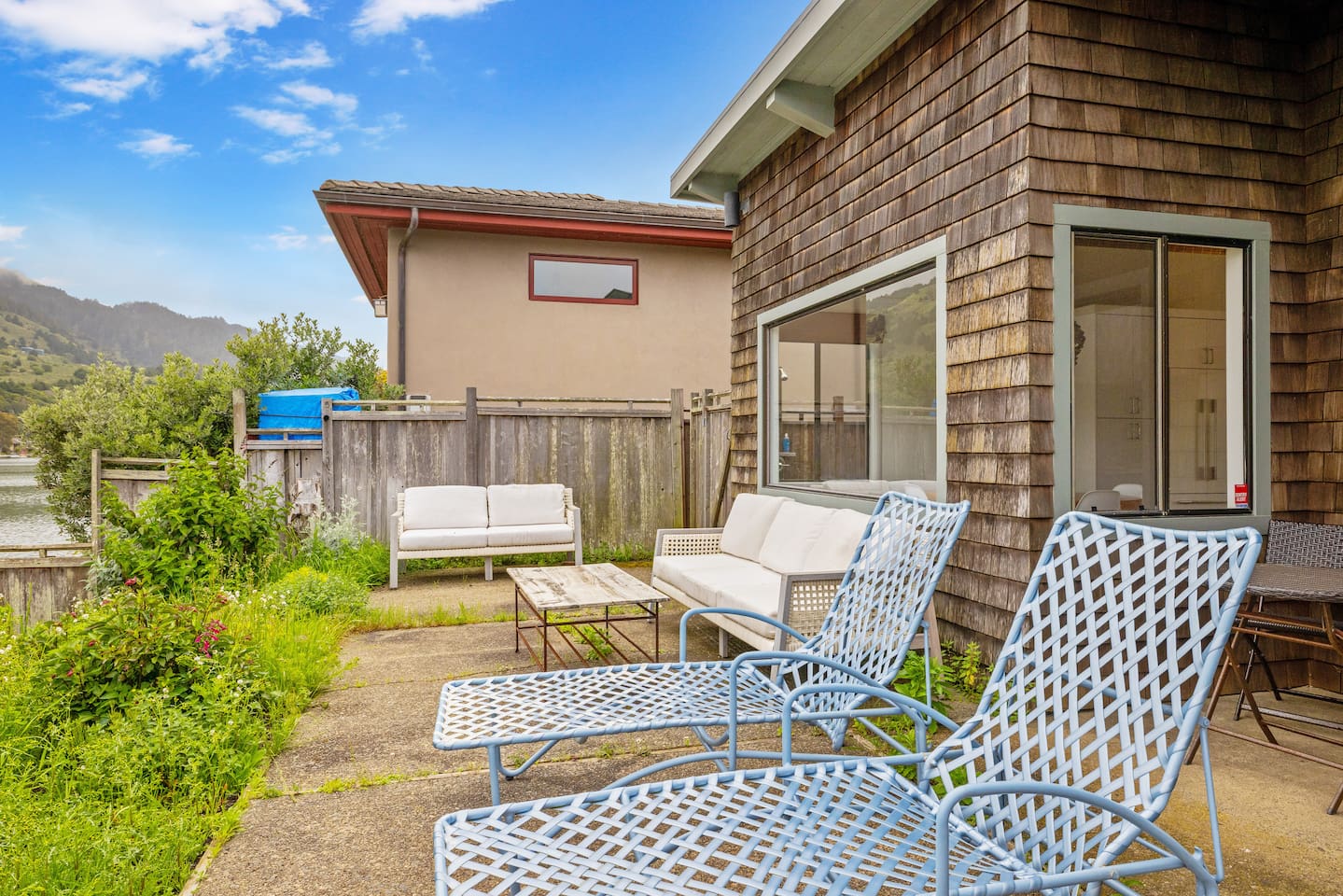 Outdoor lounge chairs on a private patio by the water.

