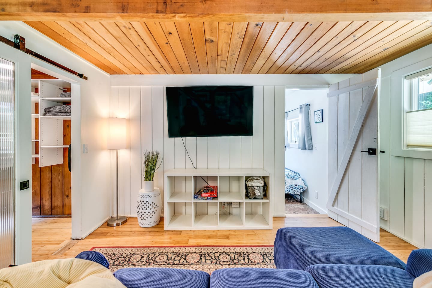 The cozy tv den is ready for popcorn and snuggles. In the wire basket there is a PUP BLANKET to drape over the couch so your fur baby can snuggle with you.