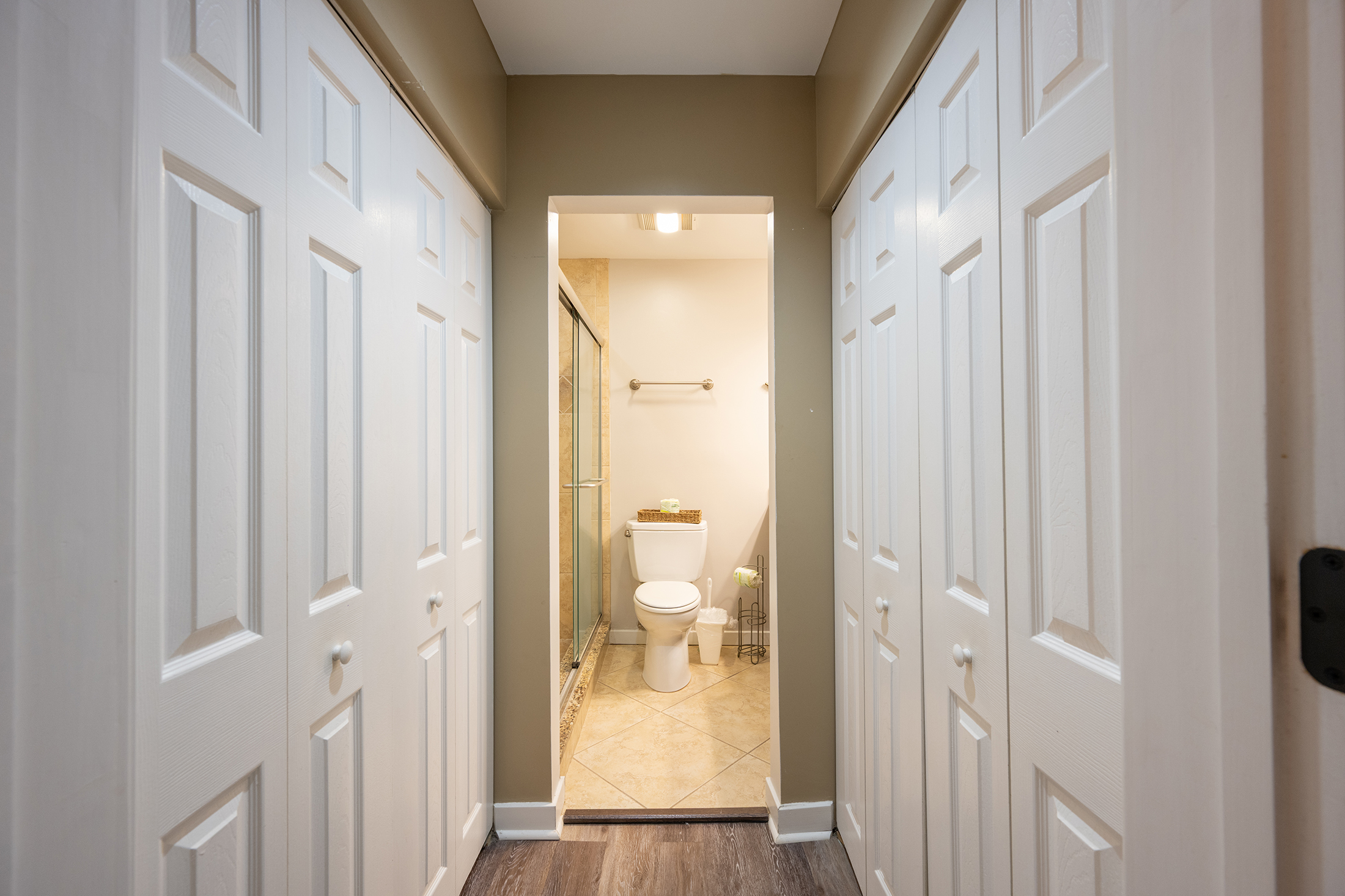 Hallway from Primary bedroom to private bath with closets on both sides