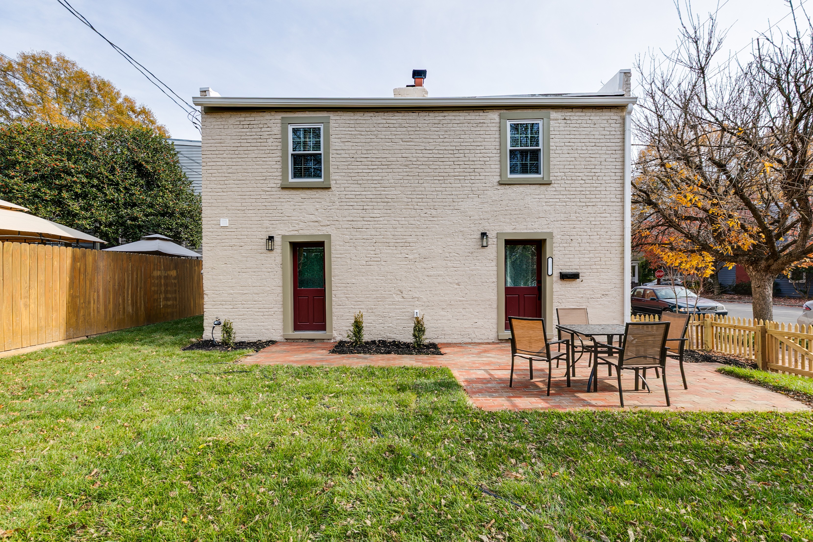 Charming Exterior: Relax on the patio surrounded by lush greenery and inviting brick pathways!