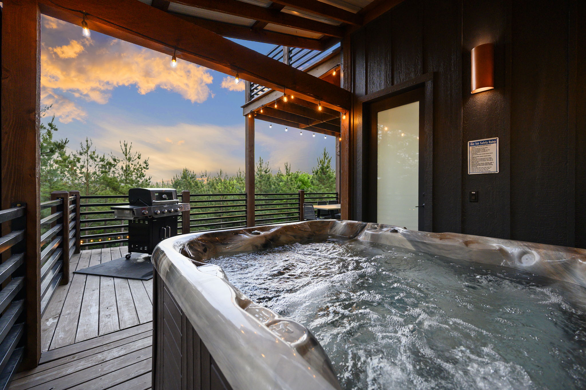 Covered hot tub with forest views—unwind in total privacy at this luxury Hochatown cabin retreat.