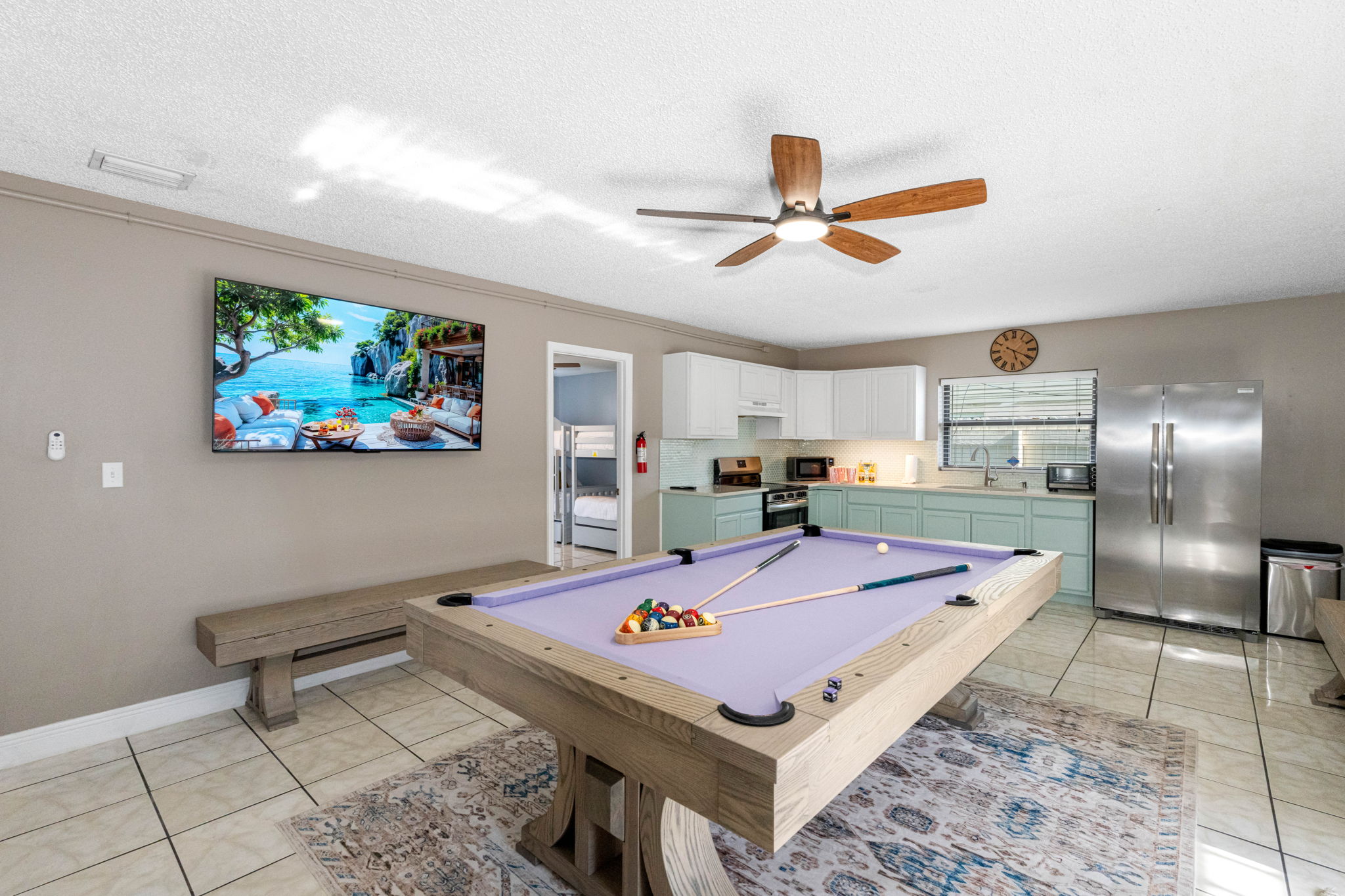 This room is designed for connection—with a dining table that doubles as a ping pong arena, a foosball table for added fun, and a fully stocked kitchen just steps away.