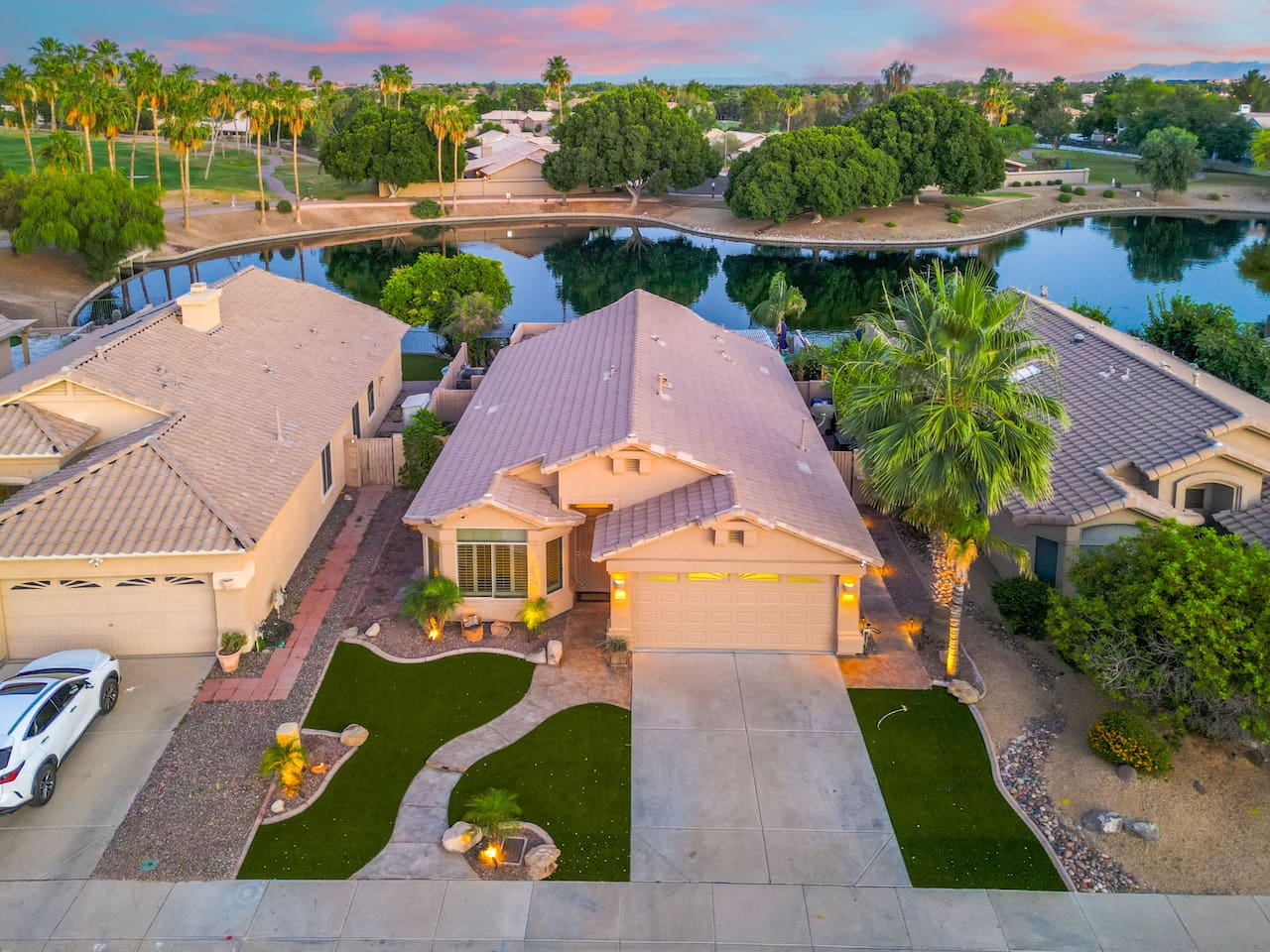 From above, the full picture comes into view — a beautifully kept home sitting right on the lake, surrounded by lush greenery and the natural beauty of the Arizona landscape.