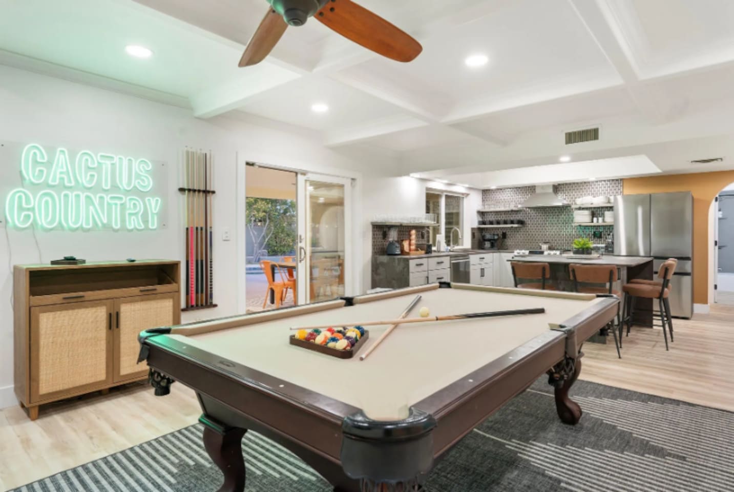 Another look at the game room shows the open flow between the pool table, kitchen, and lounge, easy sightlines for staying part of the group.
