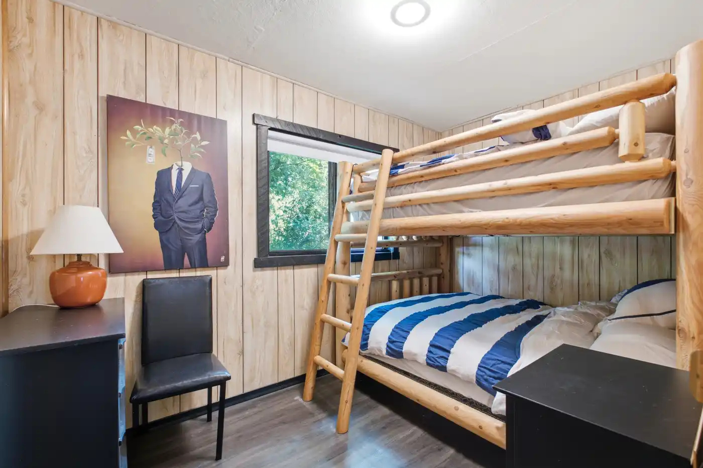 Bunk room with dresser and warm wood interior