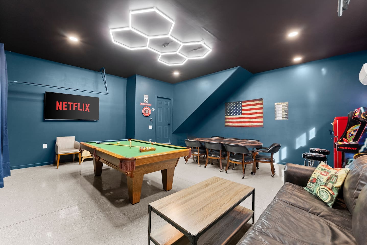 Ultimate game cave with billiards, poker table, arcade games, comfy couch, and a TV—fun for all ages.