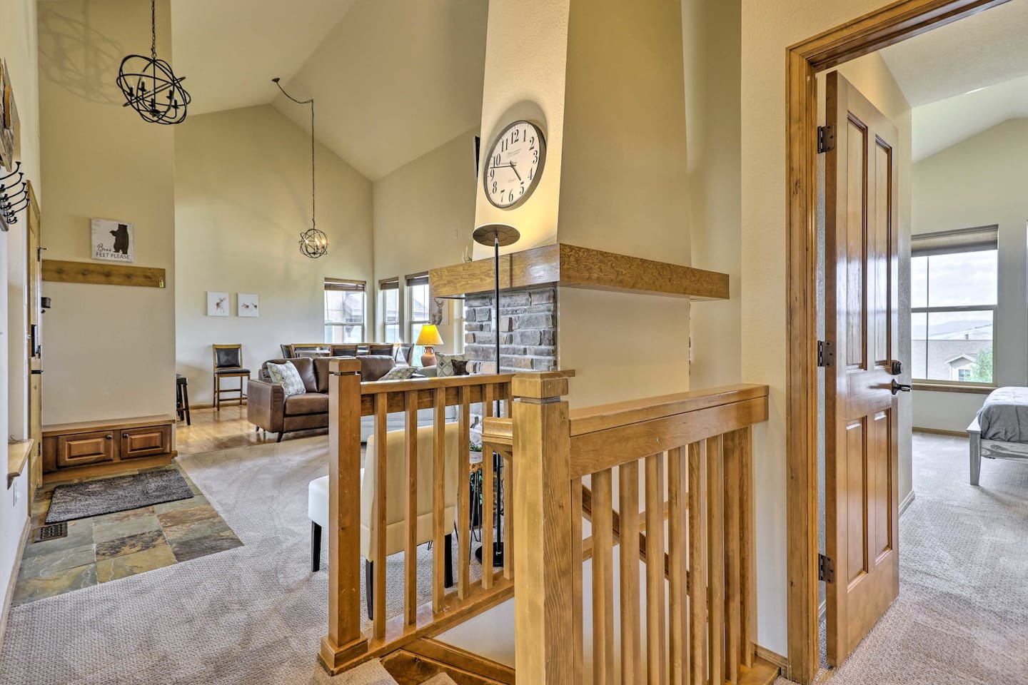 Hallway View with Upstairs Living Room, Front Door, entrance to Primary Suite, and stairs downstairs
