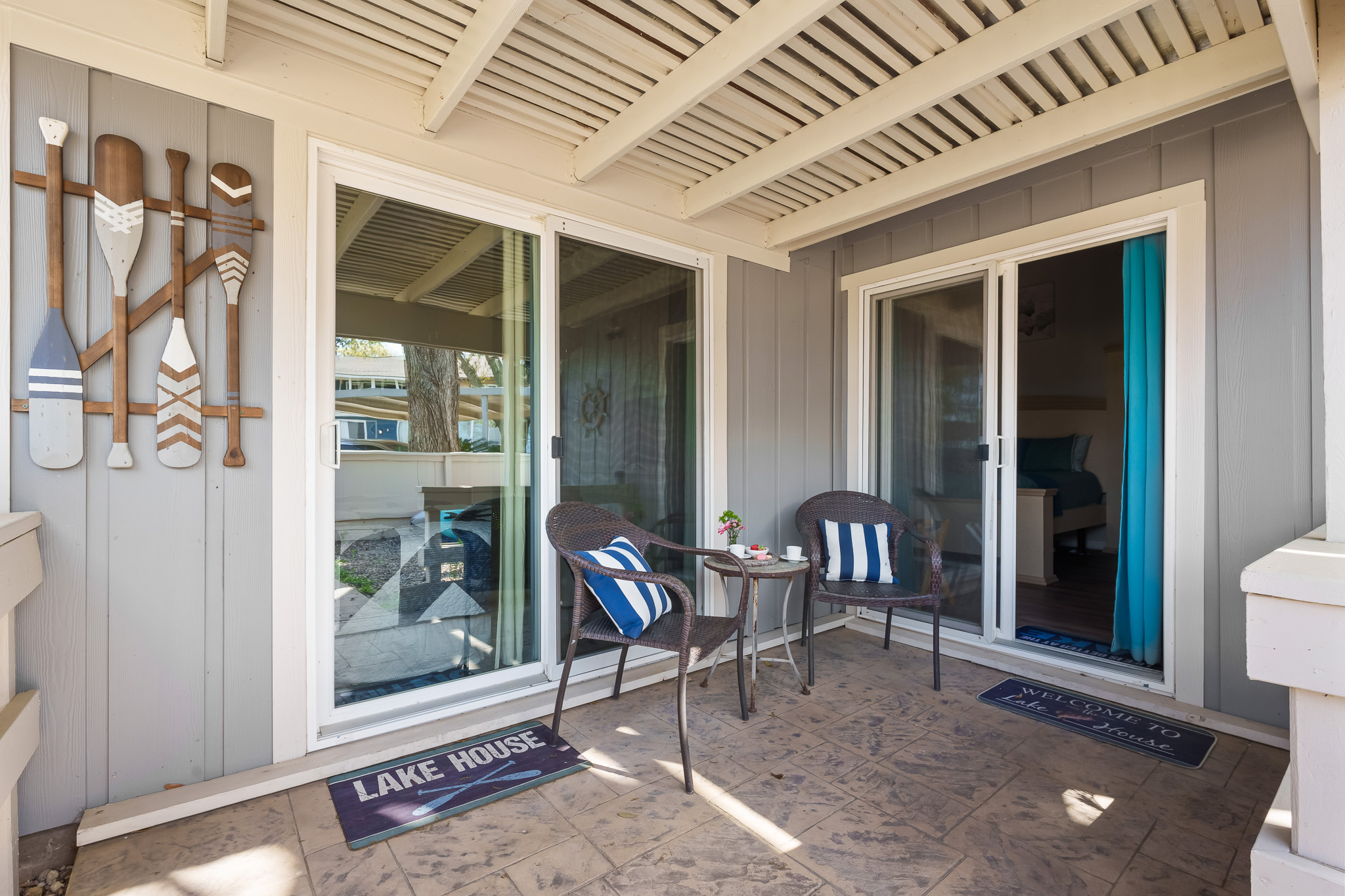 Tucked just outside the master bedroom, this charming covered patio offers a cozy spot to sip your morning coffee or unwind in the evening. With cushioned seating, nautical décor, and welcoming touches, it’s your own peaceful corner of lake life.