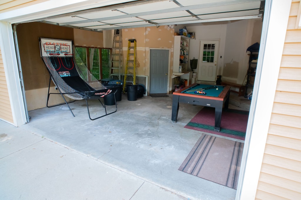 Pool table and basketball game in garage. There's also a cornhole game.