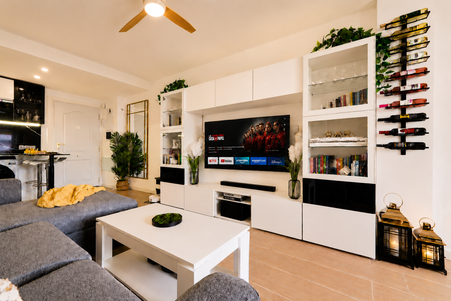 Stylish open-plan living room with a modern kitchen, smart TV, and natural light throughout — ideal for relaxing or sharing a glass of wine after a day by the beach.