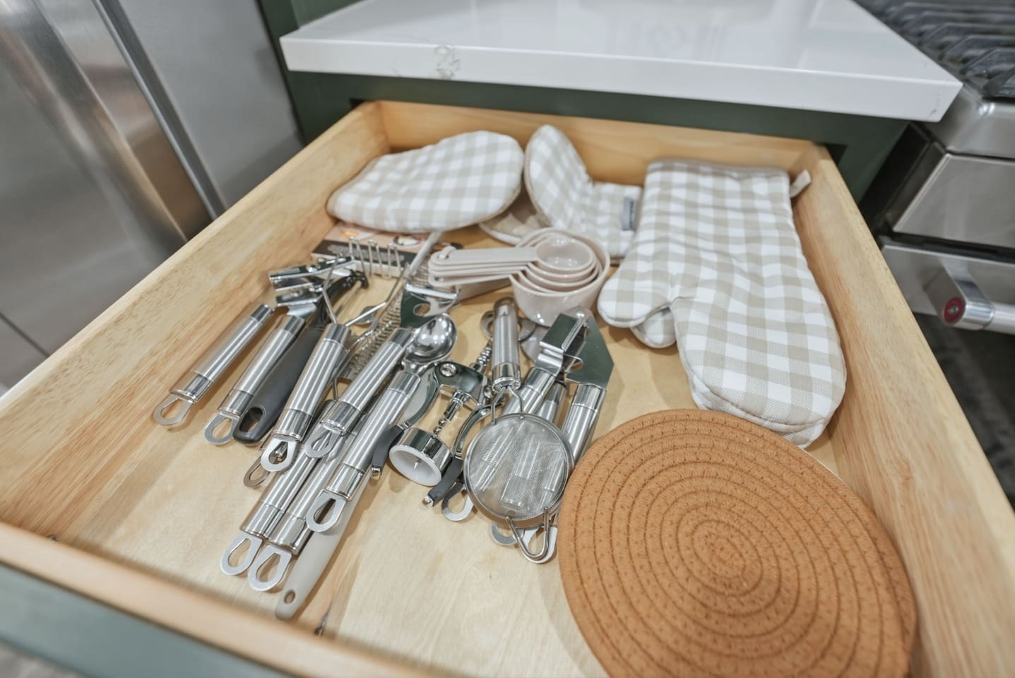 Fully stocked utensil drawer featuring measuring spoons, kitchen tools, oven mitts, and cooking accessories for effortless meal prep.