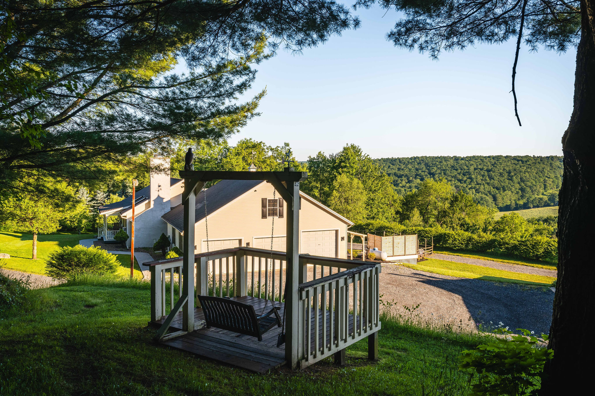 Romantic porch swing on the hill above the farmhouse with vista views beyond.