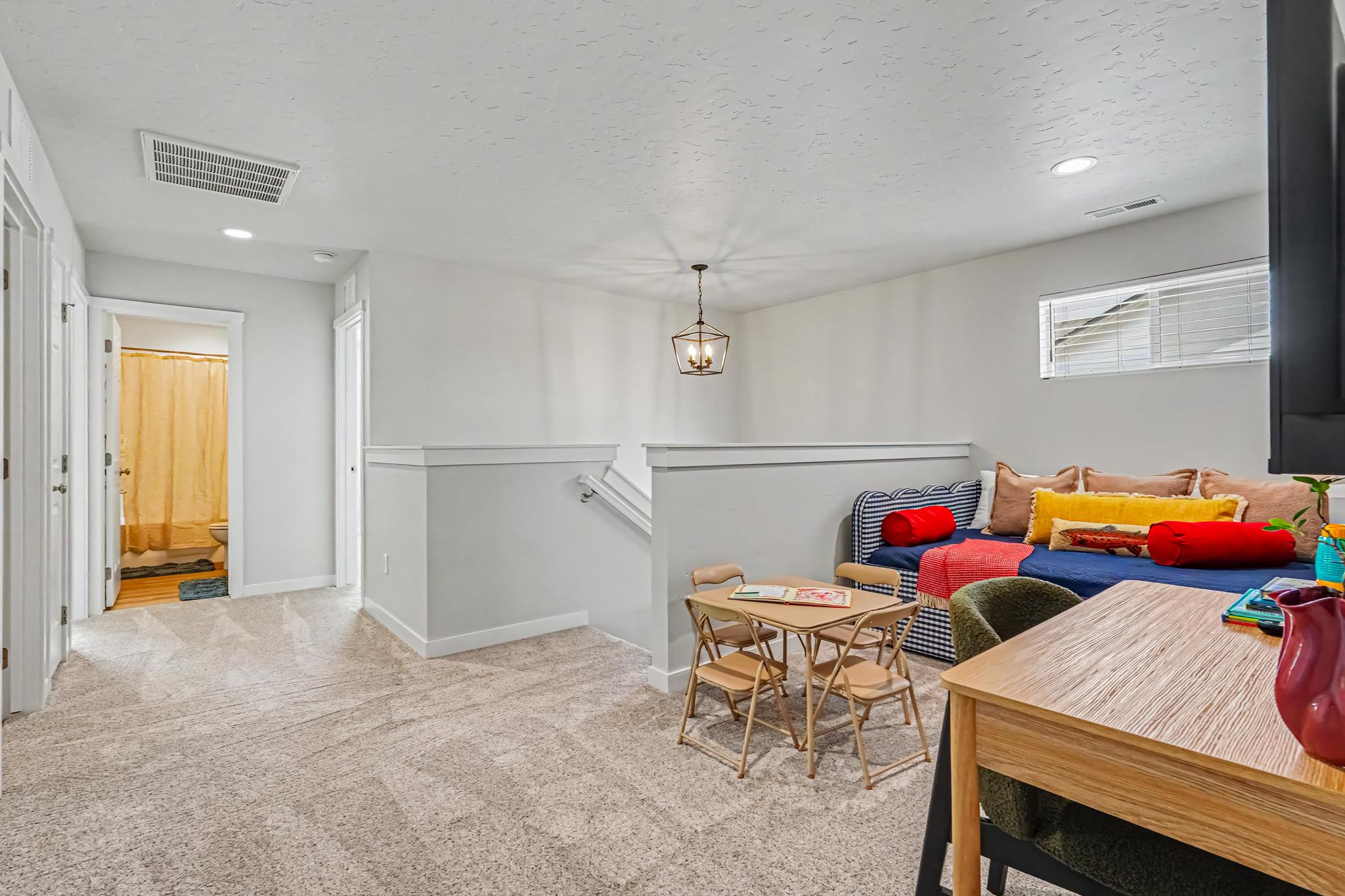 This upstairs area is a bounce room with a smart TV and a small kids' table for activities.