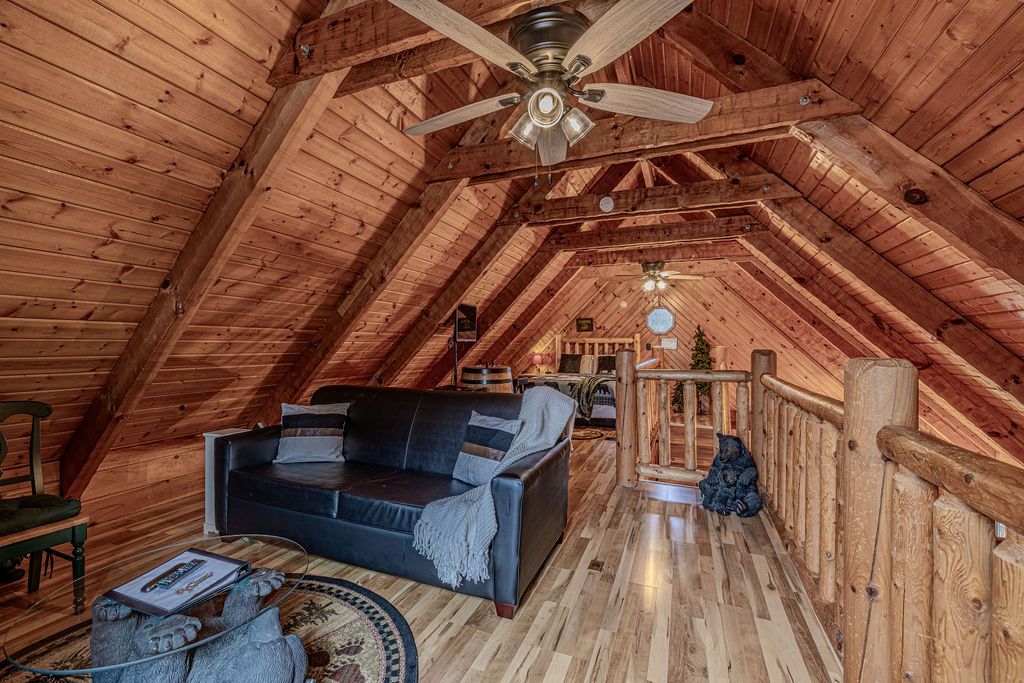 Loft living area with vaulted ceilings and TV